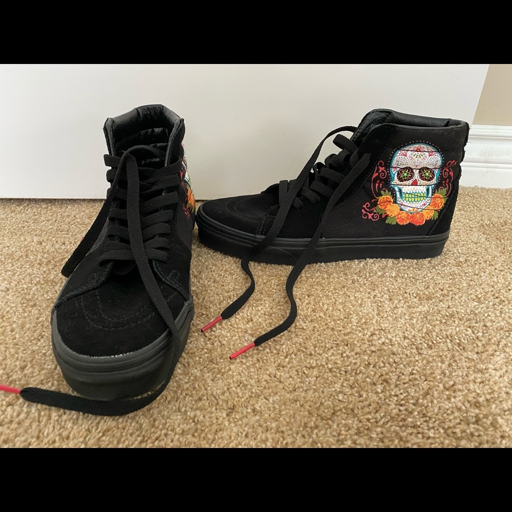 All black vans with sugar skulls on side